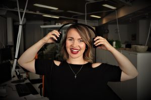 woman with headphones on in front of a mic