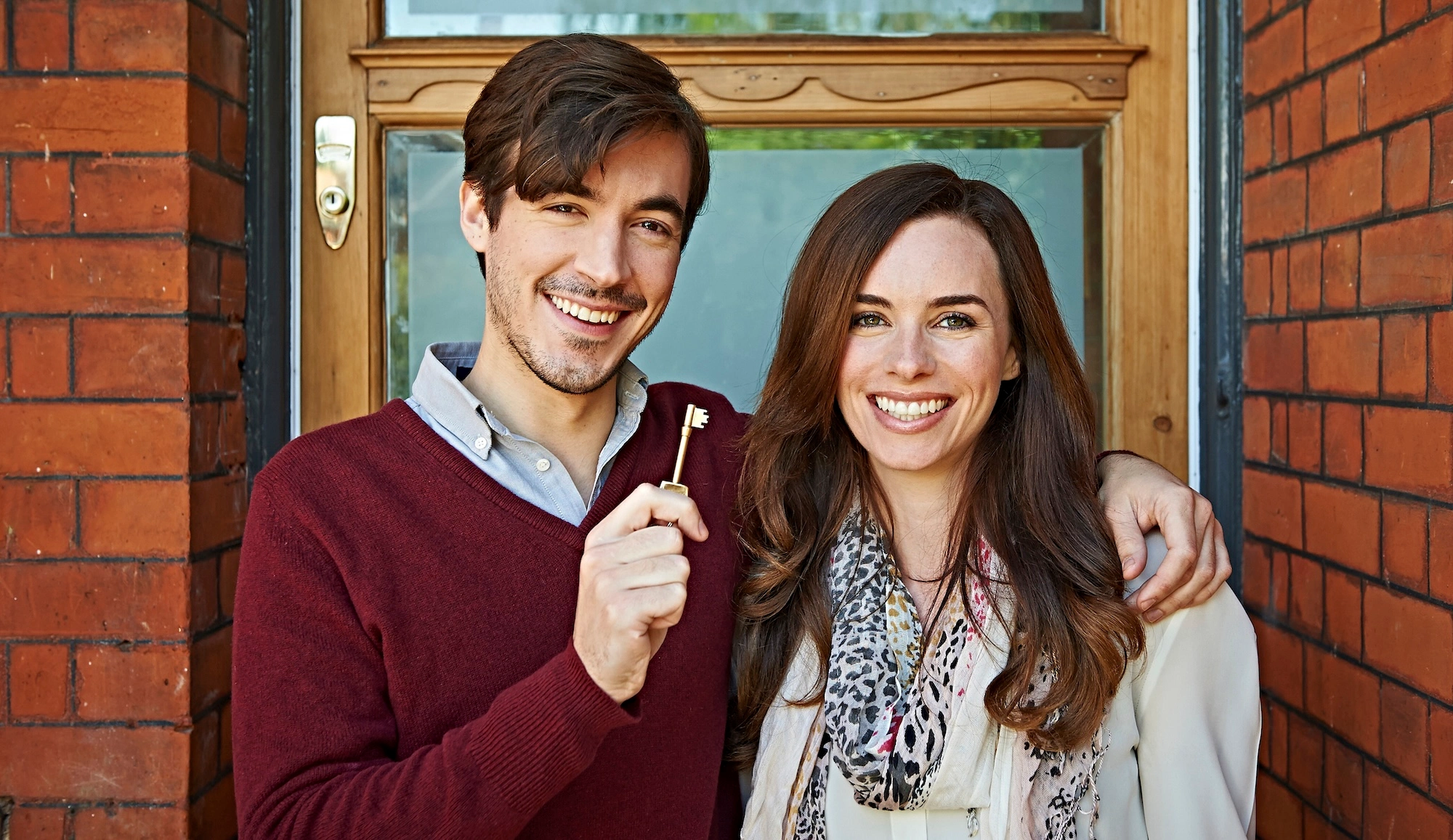happy couple holding a key to a new house